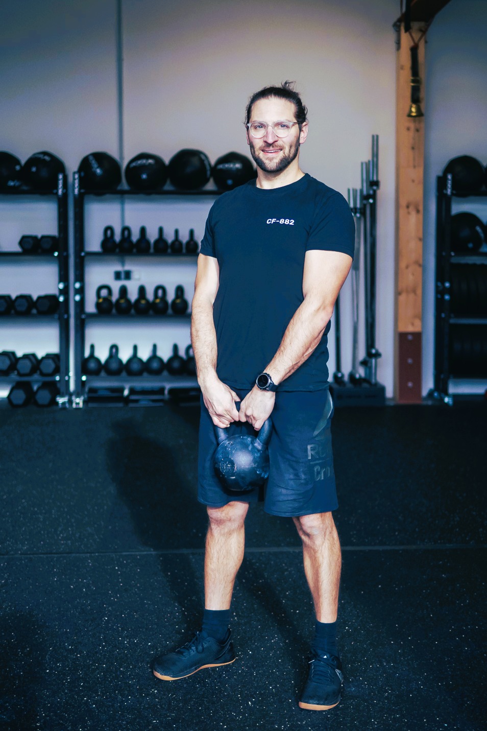 Max stehend hält eine Kettlebell in den Händen